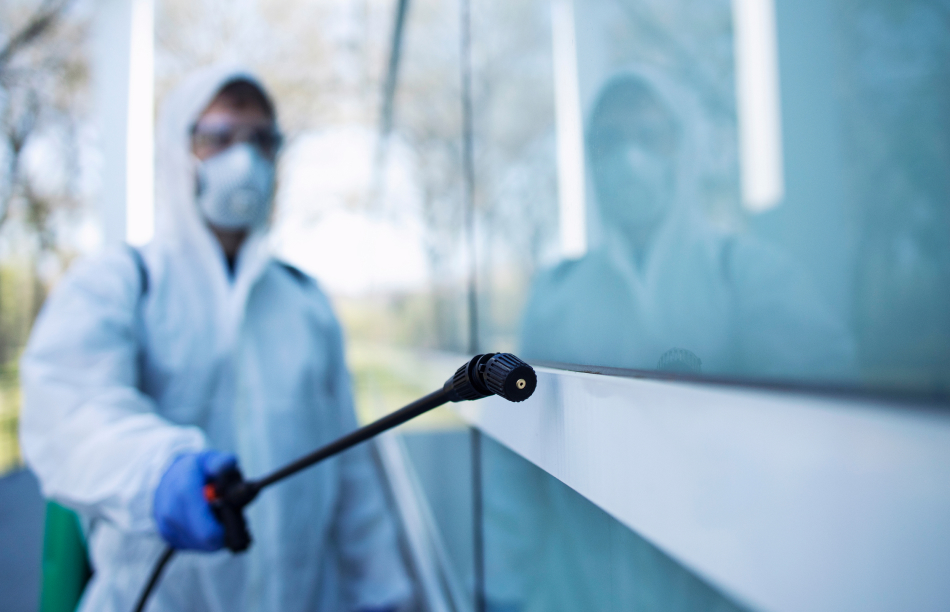 person-disinfecting-dangerous-area-while-wearing-protective-suit-green-1-1
